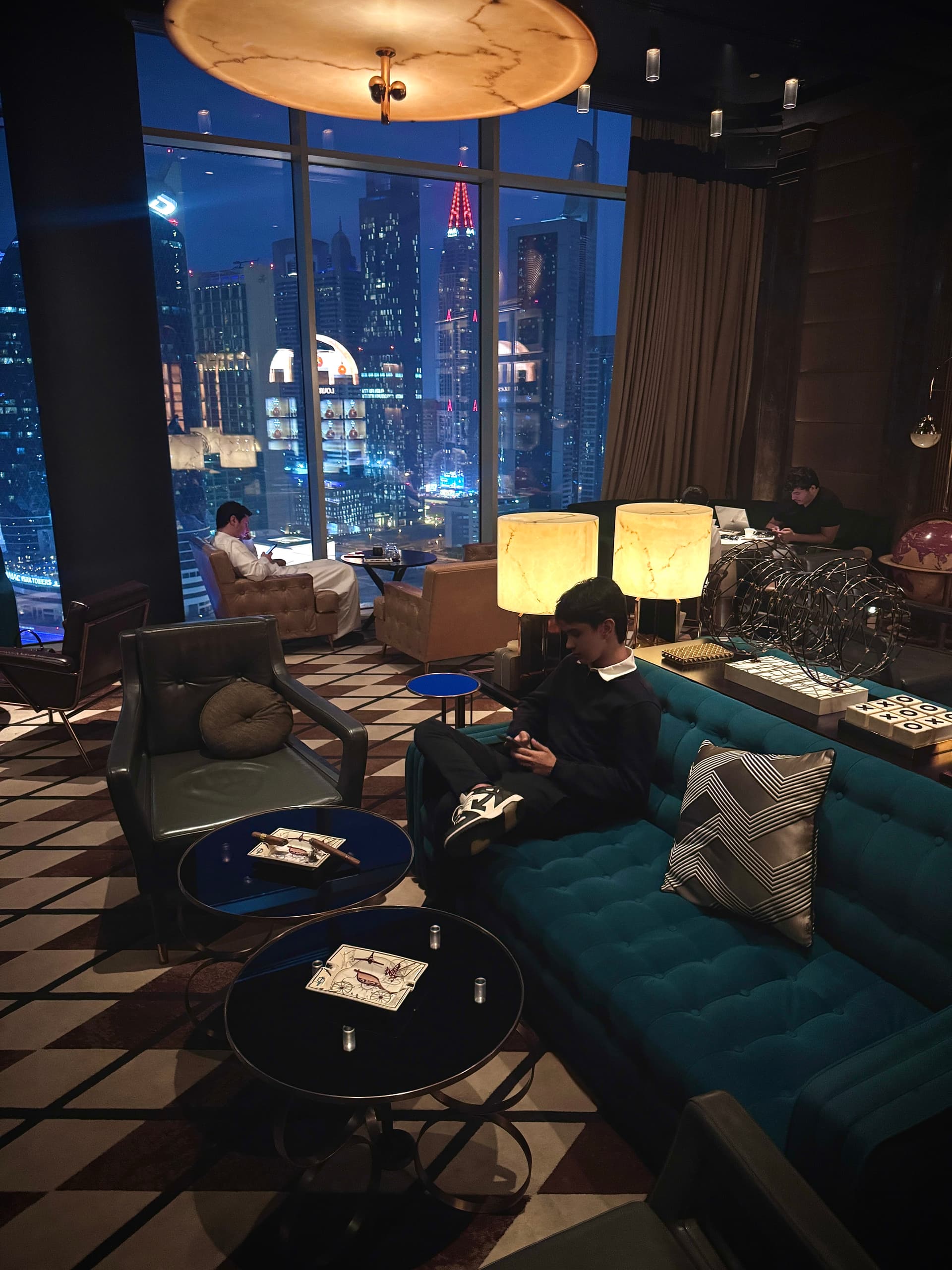 Arthur Oliveira em lounge de luxo em Dubai com skyline ao fundo